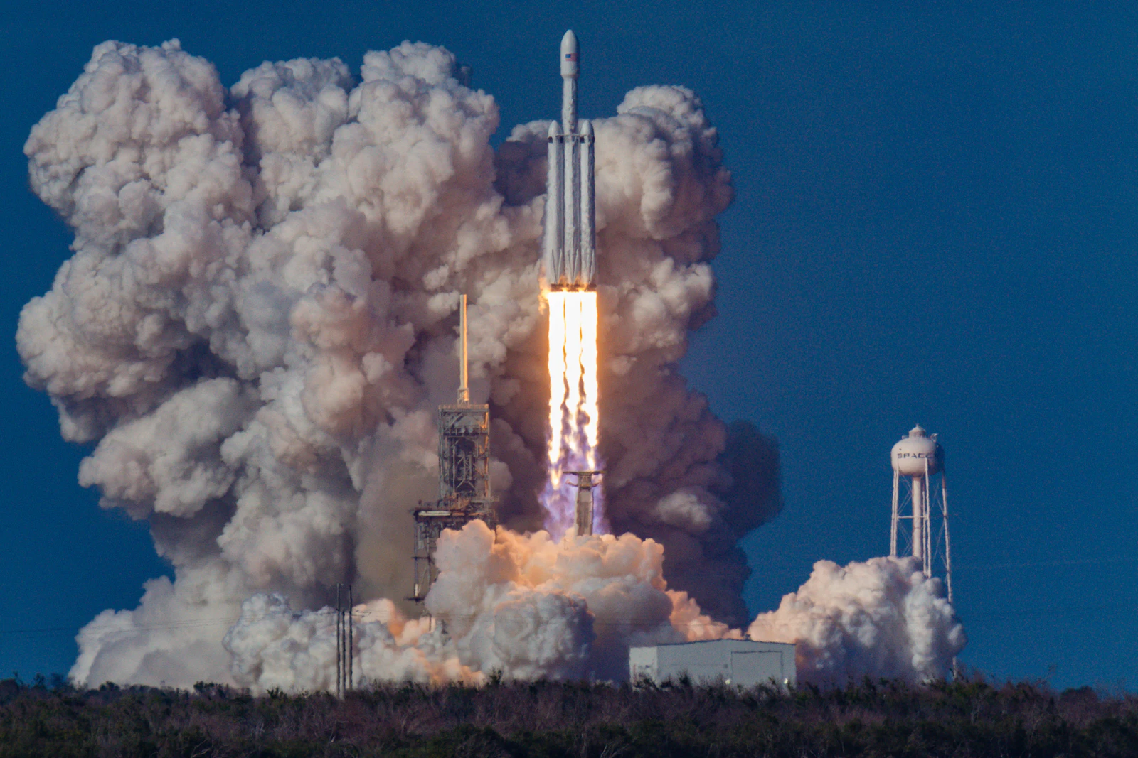 A heavy rocket lifting off amid an enormous plume